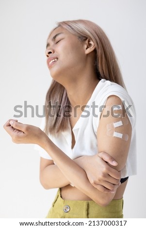 Concept image of fully vaccinated asian woman with second booster, total four shots in vaccine immunity program, concept of boosted inoculation, experiencing adverse event side effect after injection Royalty-Free Stock Photo #2137000317
