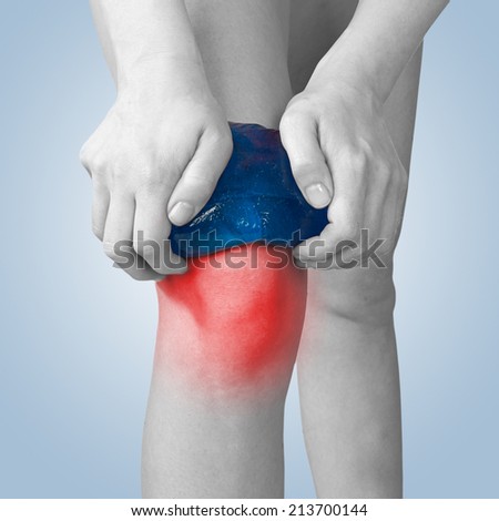 Acute pain in a knee. Woman holding hand to spot of knee-aches.