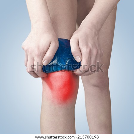 Acute pain in a knee. Woman holding hand to spot of knee-aches.