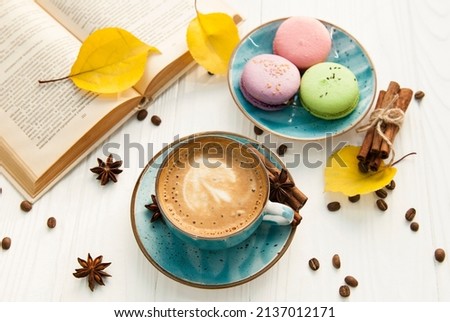 Coffee cup, macaroons and book on white background 