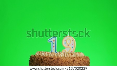 Cake with lighted candle number 19. Green screen background. Isolated.