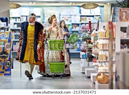 What say ye to this brand, my lady. A king and queen browsing in a supermarket. Royalty-Free Stock Photo #2137031471