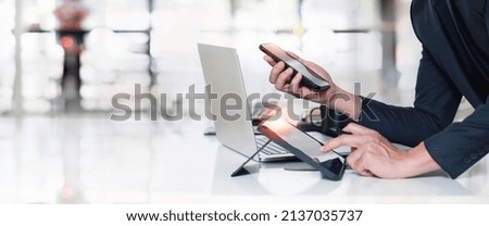 Man using smart phone, digital tablet and laptop computer at office.