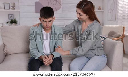 Mother consoling her depressed son at home. Teenager problems Royalty-Free Stock Photo #2137046697