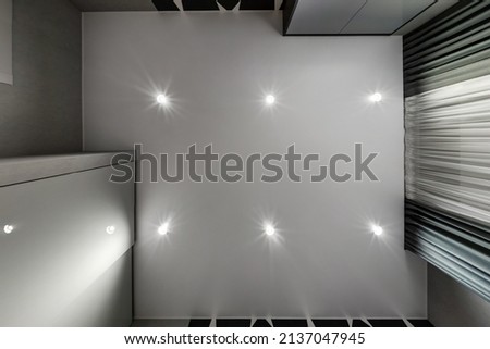 suspended ceiling with halogen spots lamps and drywall construction in empty room in apartment or house. Stretch ceiling white and complex shape. Royalty-Free Stock Photo #2137047945