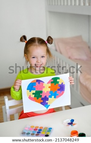 Kid drew a picture of a heart from puzzles as a gift to a friend suffering from autism. Teaching tolerance, tolerance and awareness. Learning tolerance, tolerance and awareness for people with disease