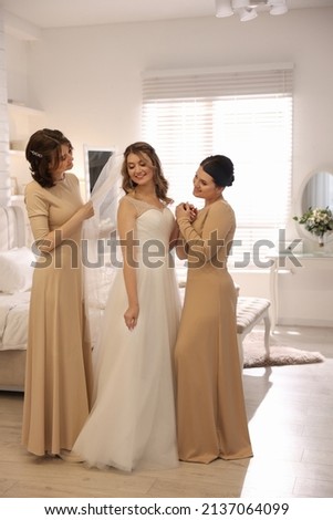 Happy bride and bridesmaids in room at home. Wedding day