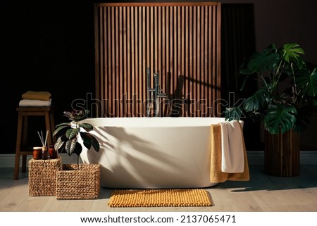 Cozy bathroom interior with stylish ceramic tub Royalty-Free Stock Photo #2137065471