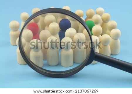 Group of not colored figures with  few colored under magnifying glass on blue background. Choosing personnel and hire employers, HR and people recognition concept. Royalty-Free Stock Photo #2137067269
