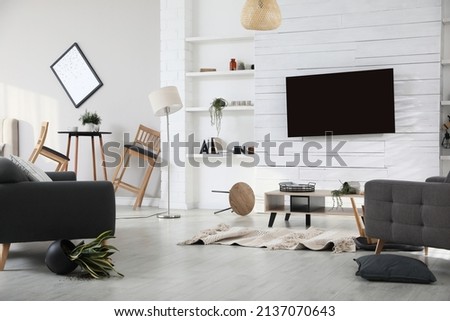 Chaotic living room interior after strong earthquake Royalty-Free Stock Photo #2137070643