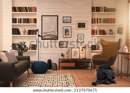 Cozy home library interior with comfortable furniture and collection of different books on shelves