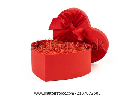 Red heart-shaped gift box with a red ribbon on white background. Happy Valentine's Day. Anniversary. 
