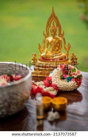 Flower garlands, water bowls, perfume and white clay filler for Buddha bathing ceremony on important religious days for Buddhists, New Year's and Songkran Festivals for Asians. Royalty-Free Stock Photo #2137073587