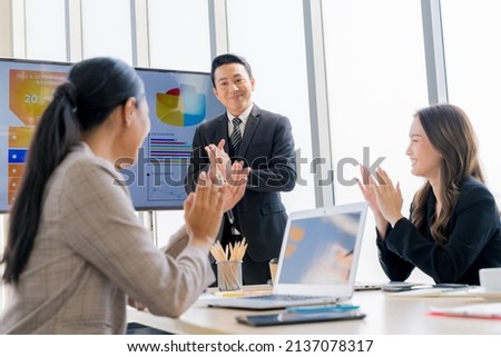 Cheerful young Asian businessman Excited and glad applauded. About successful startup projects Happy Asian colleagues celebrating business success in office meeting. Royalty-Free Stock Photo #2137078317