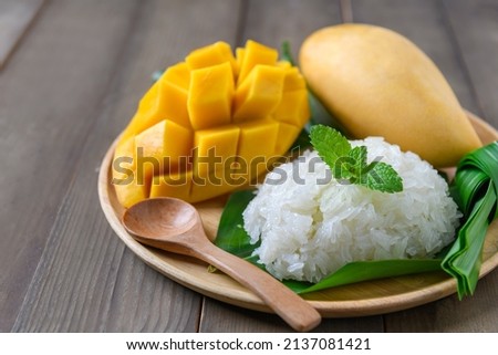 Coconut Flavored Sticky Rice with Ripe Mango on wood dish, Popular Thai desserts on summer. Royalty-Free Stock Photo #2137081421