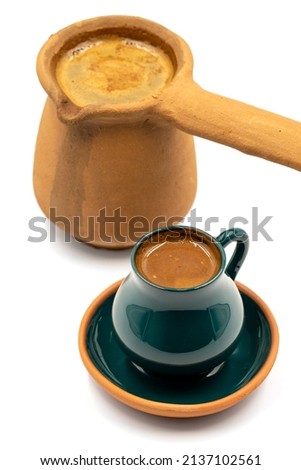 Turkish coffee on a white background. Rustic cup and earthen coffee pot.