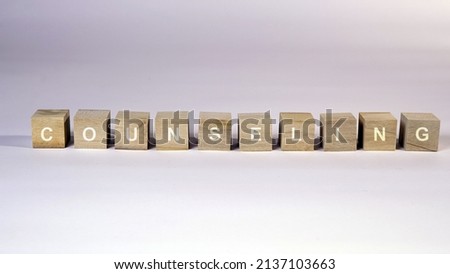 Counseling word written on wood block. The text COUNSELING is written on the cubes in white letters, the cubes are located on a white paper.                                   