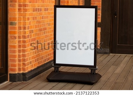 Signboard on the street. Empty menu board stand. Restaurant sidewalk sign board. Freestanding board near outdoor cafe. Copyspace for text, selective focus. Royalty-Free Stock Photo #2137122353