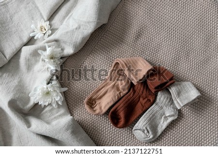 Children's socks are laid out on a linen bedspread. Photo content for a baby store.  Royalty-Free Stock Photo #2137122751
