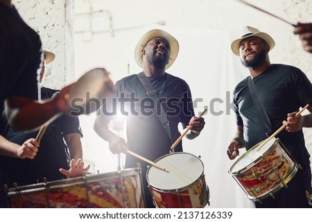 Their beats are on a whole new level. Shot of a group of musical performers playing drums together. Royalty-Free Stock Photo #2137126339