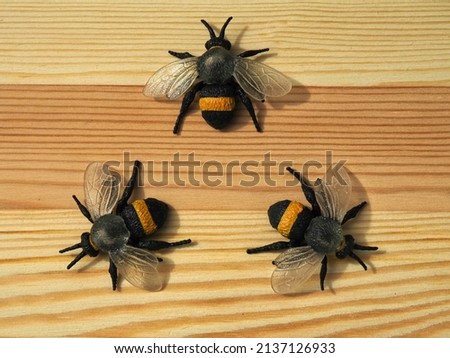 Toy bees on a wooden background. Honey collection and plant pollination. Environmental ecology