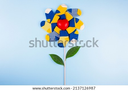 World Down Syndrome Day background. Different socks with heart on blue background. Down syndrome awareness concept. Odd socks as symbol of Down Syndrome.  Royalty-Free Stock Photo #2137126987