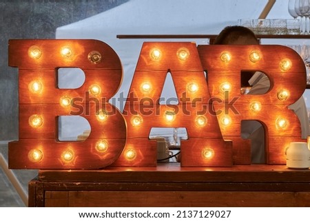 The inscription BAR . The inscription BAR from large wooden letters decorated with luminous bulbs.