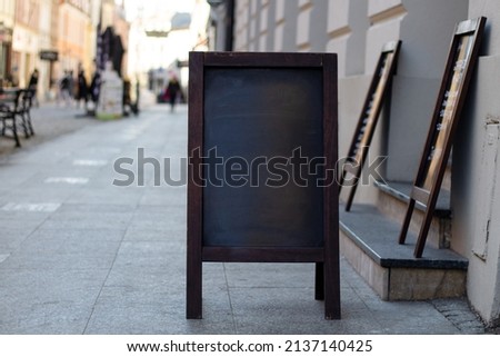 Signboard on the street. Empty menu board stand. Restaurant sidewalk sign board. Freestanding board near outdoor cafe. Copyspace for text, selective focus.