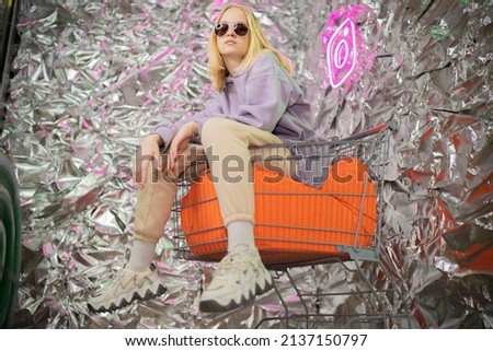 Portrait of a stylish blonde girl on a silver background.