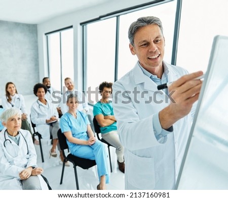 Portrait of a young doctor teaching on a seminar in a board room or during an educational class at convention center  Royalty-Free Stock Photo #2137160981