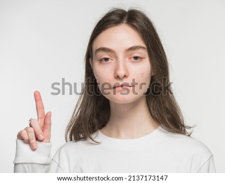 
close-up portrait of a young Ukrainian girl who shows the number with her hands on a white background