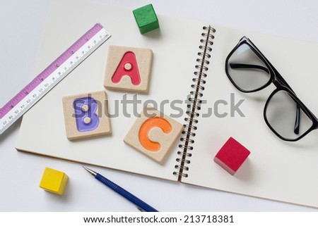 Colorful alphabet letters ,"abc" ,glasses and a pencil on the book