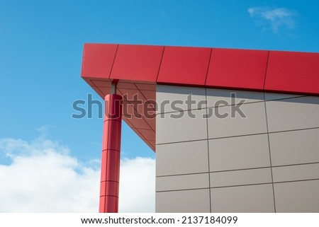 The exterior wall of a contemporary commercial style building with aluminum metal composite panels and glass windows. The futuristic building has engineered diagonal cladding steel frame panels. Royalty-Free Stock Photo #2137184099