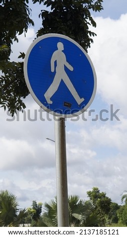 blue pedestrian crossing sign, traffic sign. The sign specifies the priority of pedestrians in this area.