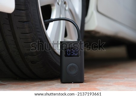 Portable cordless tire inflator. Portable air pump Royalty-Free Stock Photo #2137193661
