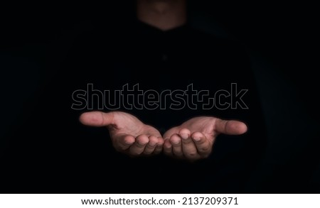 Give two hands with nothing on both on dark background with copy space. Close-up receiving gesture of outstretched cupped empty open hands. Concept of giving, donation, receiving, asking, and bribery. Royalty-Free Stock Photo #2137209371