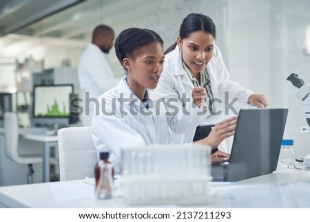 Improving lives one collaboration at a time. Shot of two young scientists using a laptop in a laboratory. Royalty-Free Stock Photo #2137211293