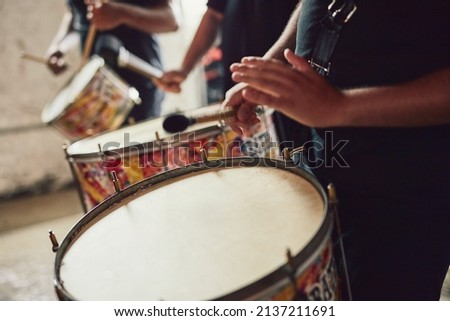 Sounds that come straight out of Brazil. Closeup shot of a musical performer playing drums with his band. Royalty-Free Stock Photo #2137211691