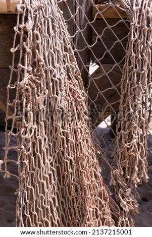 Old fishing net on the wooden pier on the beach