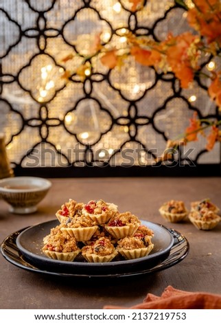 Indonesian Cookies (Fruit Pie), popular cookies during Hari Raya Idul Fitri and Christmas served on brown plate, golden table and background.  Royalty-Free Stock Photo #2137219753