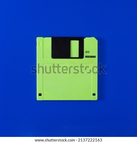 green floppy disks on a blue background. flatlay and copy space.