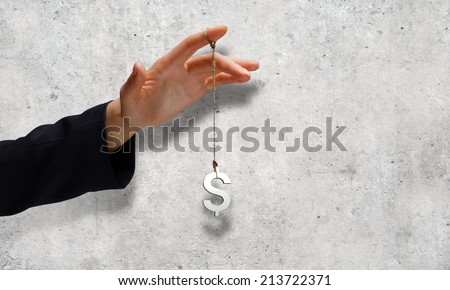 Close up of businessman hand and dollar sign hanging on finger