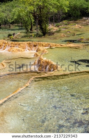 Yellow stone natural terraces, emerald clean water, close up in Huanglong Scenic Area, Sichuan, China, vertical size picture 