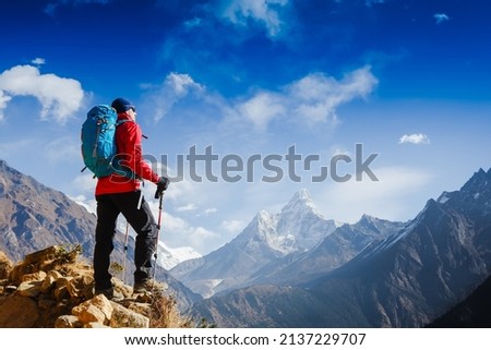 Hiker cheering elated and blissful with arms raised in the sky after hiking. Everest base camp trek Royalty-Free Stock Photo #2137229707