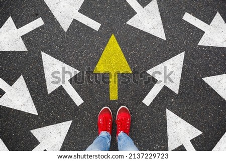 Person standing on the road to future life with many direction sign point in different ways and only yellow one. Decision making is very hard, but you have a choice and right way Royalty-Free Stock Photo #2137229723