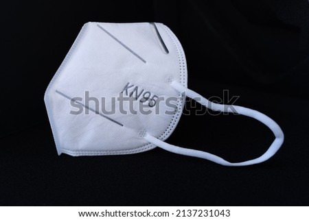 5 layer shear white KN95 FPP2 antivirus medical mask for protection against coronavirus on a black background. Doctor mask prevention of the spread of virus and pandemic COVID-19.  Royalty-Free Stock Photo #2137231043
