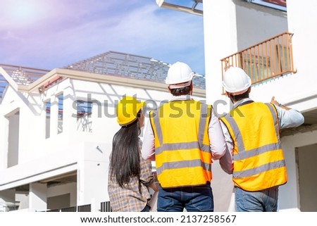 Team engineer and architects are meeting to plan for new project measuring layout of building blueprints in construction site,Construction residential new house in progress at building site. Royalty-Free Stock Photo #2137258567