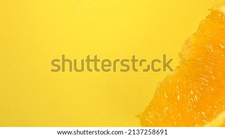 A slice of orange. On an orange background. Close up. Place for text.