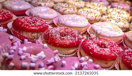 Close up of different donuts with sugar, frosted, glaze, and sprinkles.