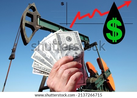 Hand holding US dollar bills in front of graph growth money with red up arrow and US dollar symbol in a drop of crude oil. Increasing oil price as a concept
